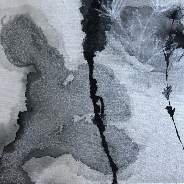 Close-up of abstract black and white artwork on a canvas surface